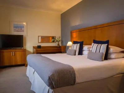 a bedroom with a large bed and a flat screen tv at Highgrove House Hotel in Loans