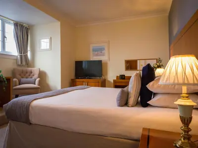 a hotel room with a bed and a television at Highgrove House Hotel in Loans