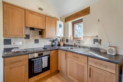 a kitchen with wooden cabinets and a stove top oven at 3 Bed in Waberthwaite oc-d31079 in Waberthwaite