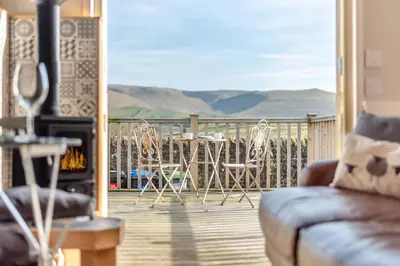 a living room with a balcony with a table and chairs at 1 Bed in Uldale oc-m31080 in Uldale