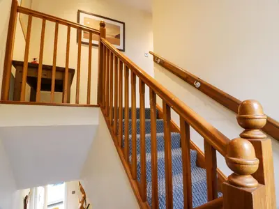 a staircase with wooden railings in a home at The Lamphouse in Stranraer