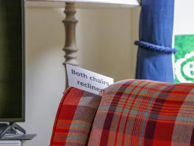 a sign sitting on the back of a plaid couch at The Lamphouse in Stranraer