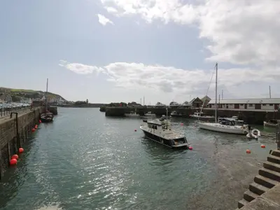 a group of boats are docked in a river at The Lamphouse in Stranraer