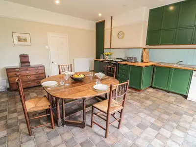 a kitchen with a wooden table and chairs in a kitchen at Westward Park in Wigton