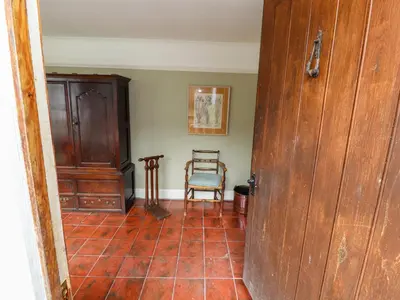 a room with a chair and a wooden door at Westward Park in Wigton