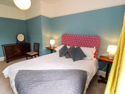 a bedroom with a large bed with a red headboard at Westward Park in Wigton