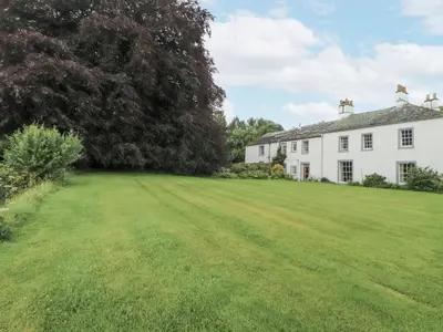 a large yard in front of a white house at Westward Park in Wigton