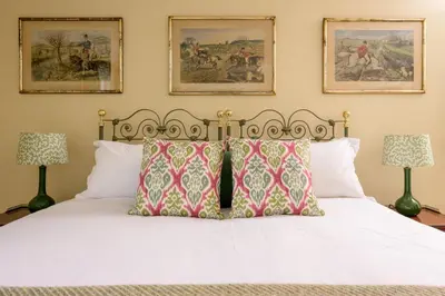 a bedroom with a white bed with two lamps at Auchengashell in Kirkcudbright