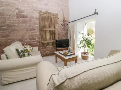 a living room with two couches and a brick wall at The Roost in Carlisle