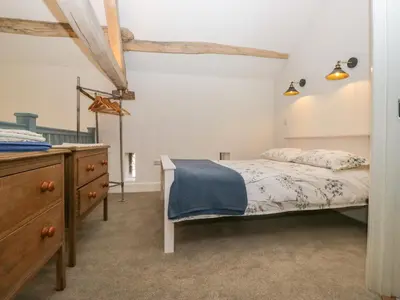 a bedroom with a bed and a wooden dresser at The Roost in Carlisle