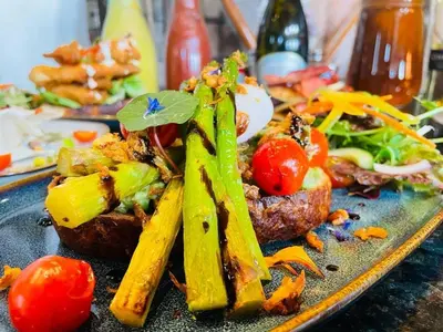 a plate of food with vegetables on a table at The Harbour House Sea Front Hotel in Portpatrick