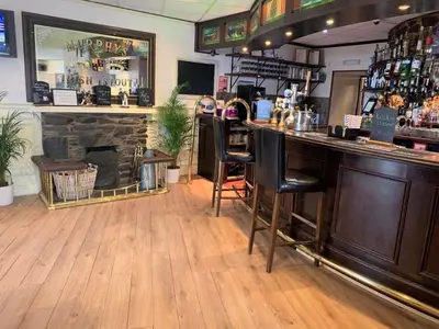 a bar in a restaurant with a fireplace at The Harbour House Sea Front Hotel in Portpatrick