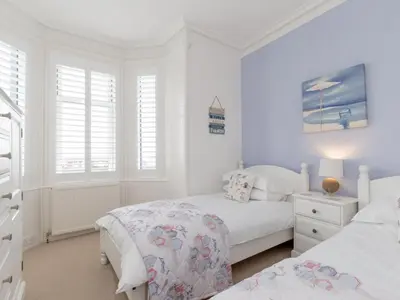 two beds in a bedroom with white walls and windows at Holiday Home The Knowe by Interhome in Portpatrick