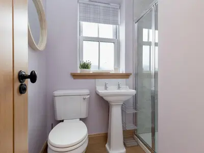 a bathroom with a toilet and a sink and a window at Holiday Home Balbeg Cottage by Interhome in Straiton