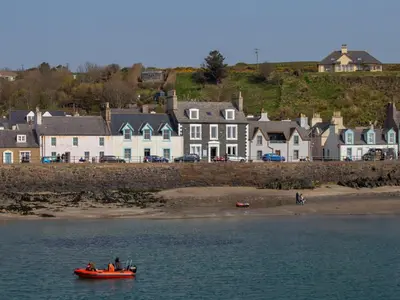 a group of people in a red boat in the water at Holiday Home Portpatrick House by Interhome in Portpatrick