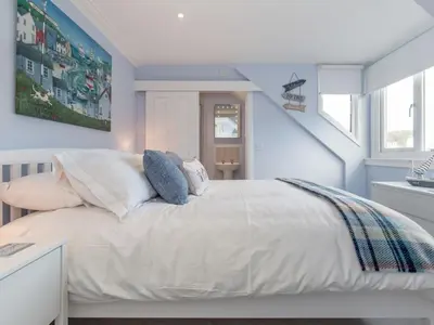 a bedroom with a white bed with blue walls at Holiday Home Portpatrick House by Interhome in Portpatrick