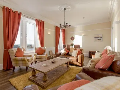 a living room with red curtains and a table at Holiday Home Portpatrick House by Interhome in Portpatrick