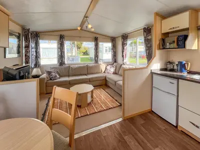 a caravan kitchen and living room with a couch and a table at The Haven in Cockermouth
