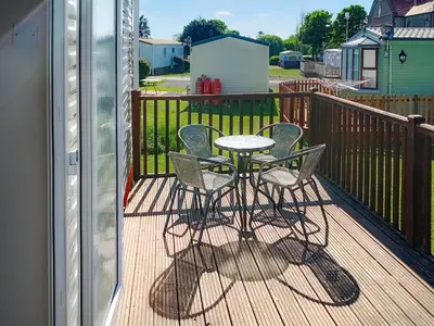 a patio with a table and chairs on a deck at The Haven in Cockermouth