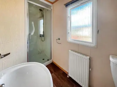 a bathroom with a shower and a toilet and a window at The Haven in Cockermouth