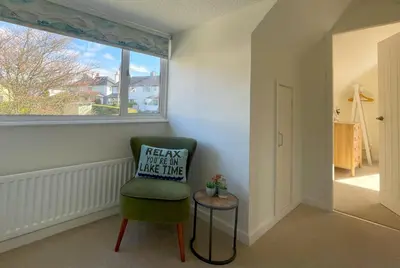 a green chair in a room with a window at Fern Cottage in Portinscale