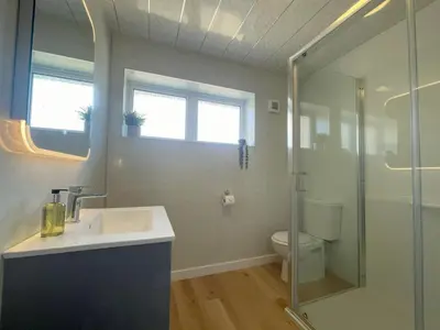 a bathroom with a sink and a shower and a toilet at Fern Cottage in Portinscale