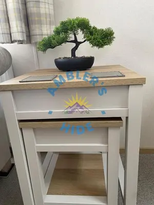 a table with a bonsai tree on top of it at Amblers Hide, Brigham, Cockermouth, Cumbria in Cockermouth