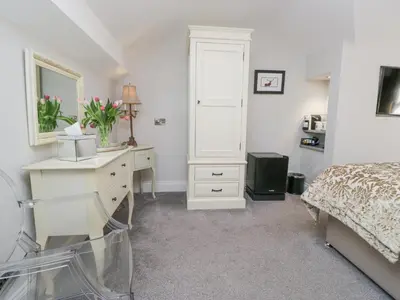 a bedroom with a desk and a bed and a dresser at Raise View House in Ambleside