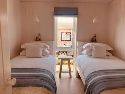two beds in a room with a window at The Moorings in Girthon
