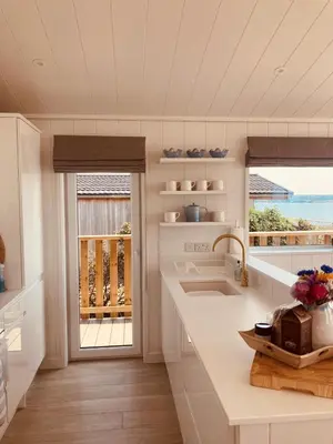 a kitchen with a sink and a window with a view of the ocean at The Moorings in Girthon