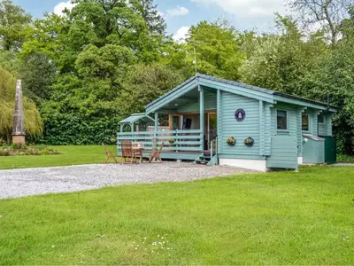 a blue tiny house in the middle of a field at Rustic Secluded Hidden Gem At Rockhall in Dumfries