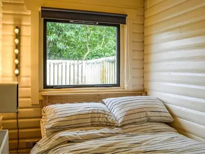a bed in the corner of a room with a window at Rustic Secluded Hidden Gem At Rockhall in Dumfries