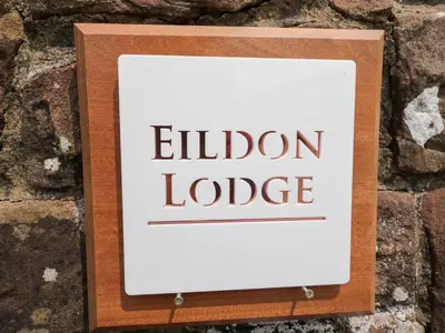 a sign that reads eliden lodge on a stone wall at Eildon Lodge in Seascale