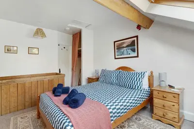 a bedroom with two beds with blue towels on them at Heron View Cottage in Grasmere