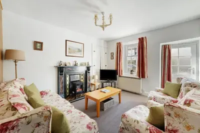 a living room with two couches and a fireplace at Heron View Cottage in Grasmere