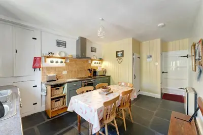 a kitchen with a table and chairs in it at Heron View Cottage in Grasmere