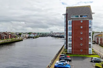 a group of cars parked next to a river at River Ayr View-Coorie Doon Stays in Ayr