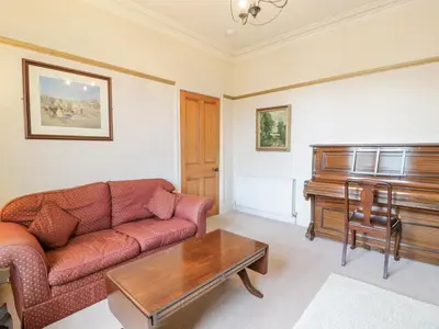 a living room with a couch and a piano at Hildawn in Dumfries