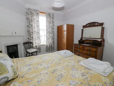 a bedroom with a bed and a dresser and a mirror at Hildawn in Dumfries
