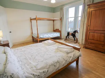 a bedroom with a bed and a dog in a window at Hildawn in Dumfries