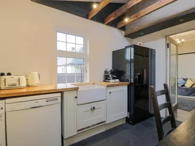 a kitchen with white cabinets and a black refrigerator at Hildawn in Dumfries