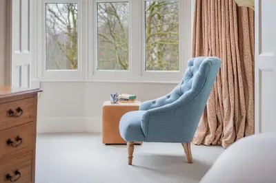 a blue chair sitting in front of a window at Huntingstile South in Ambleside