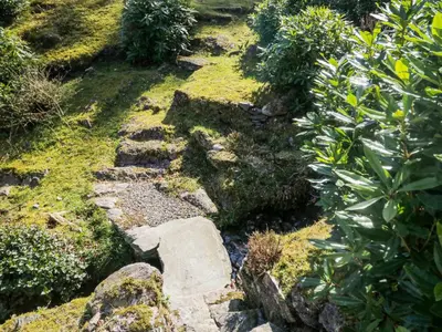 a garden with rocks and grass and plants at Huntingstile South in Ambleside
