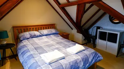 a bedroom with a bed with two pillows on it at 9 Millburn Street in Kirkcudbright