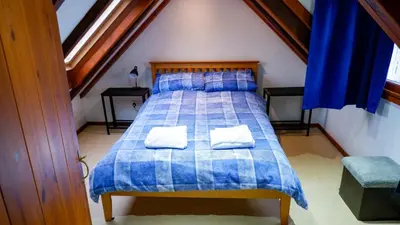 a bedroom with a bed with two pillows on it at 9 Millburn Street in Kirkcudbright