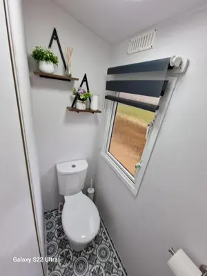 a small bathroom with a toilet and a window at Forest Valley Holiday Home in Ballantrae