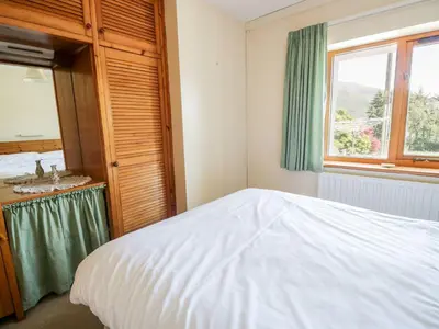 a bedroom with a bed and a sink and a window at Bramble Cottage in Keswick