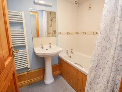 a bathroom with a sink and a bath tub at Bramble Cottage in Keswick