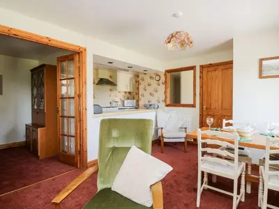 a dining room and kitchen with a table and chairs at Bramble Cottage in Keswick