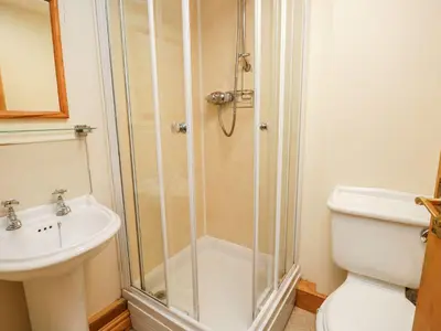 a bathroom with a shower and a toilet and a sink at Bramble Cottage in Keswick